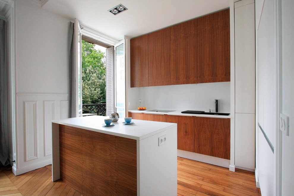 Cette photo montre une cuisine ouverte parallèle tendance en bois brun de taille moyenne avec îlot.