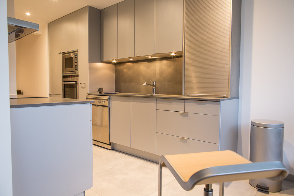 Esempio di una cucina minimal con lavello sottopiano, top in quarzite, paraspruzzi grigio, elettrodomestici in acciaio inossidabile e top grigio