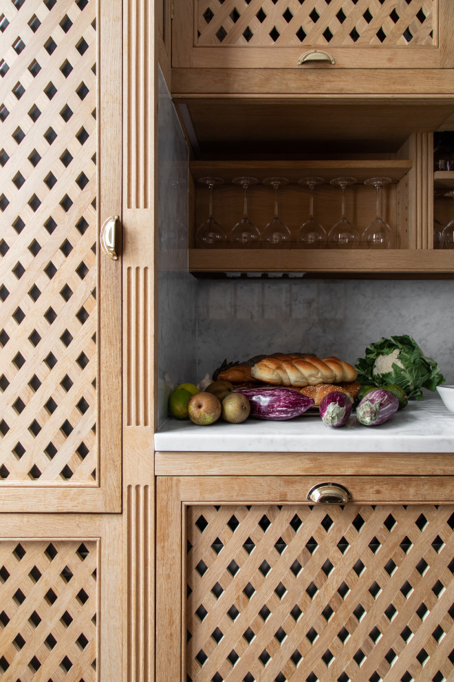 Cette image montre une cuisine parallèle et encastrable traditionnelle de taille moyenne avec plan de travail en marbre, une crédence en marbre et un sol en bois brun.