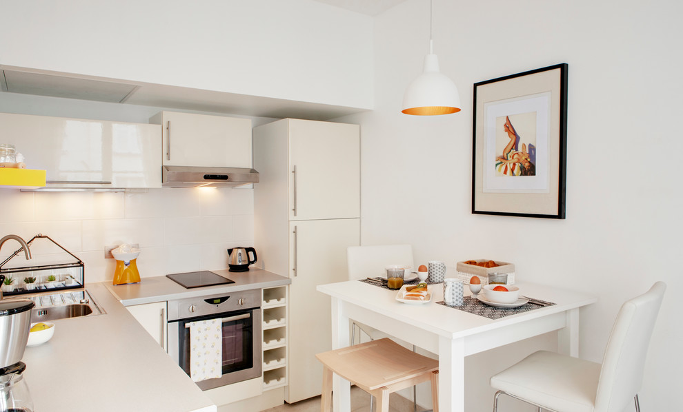 Mittelgroße Moderne Wohnküche ohne Insel in L-Form mit weißen Schränken in Paris