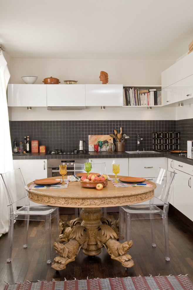 Diseño de cocina contemporánea de tamaño medio con armarios con paneles lisos, puertas de armario blancas, salpicadero negro y suelo de madera oscura