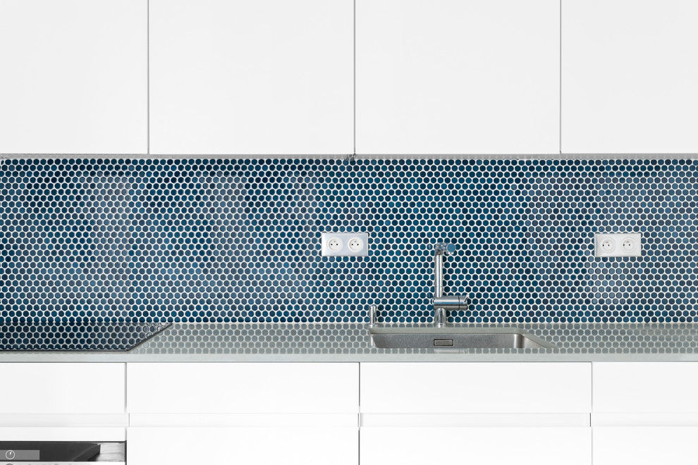 パリにある高級な小さなコンテンポラリースタイルのおしゃれなキッチン (アンダーカウンターシンク、青いキッチンパネル、モザイクタイルのキッチンパネル、パネルと同色の調理設備、セラミックタイルの床) の写真