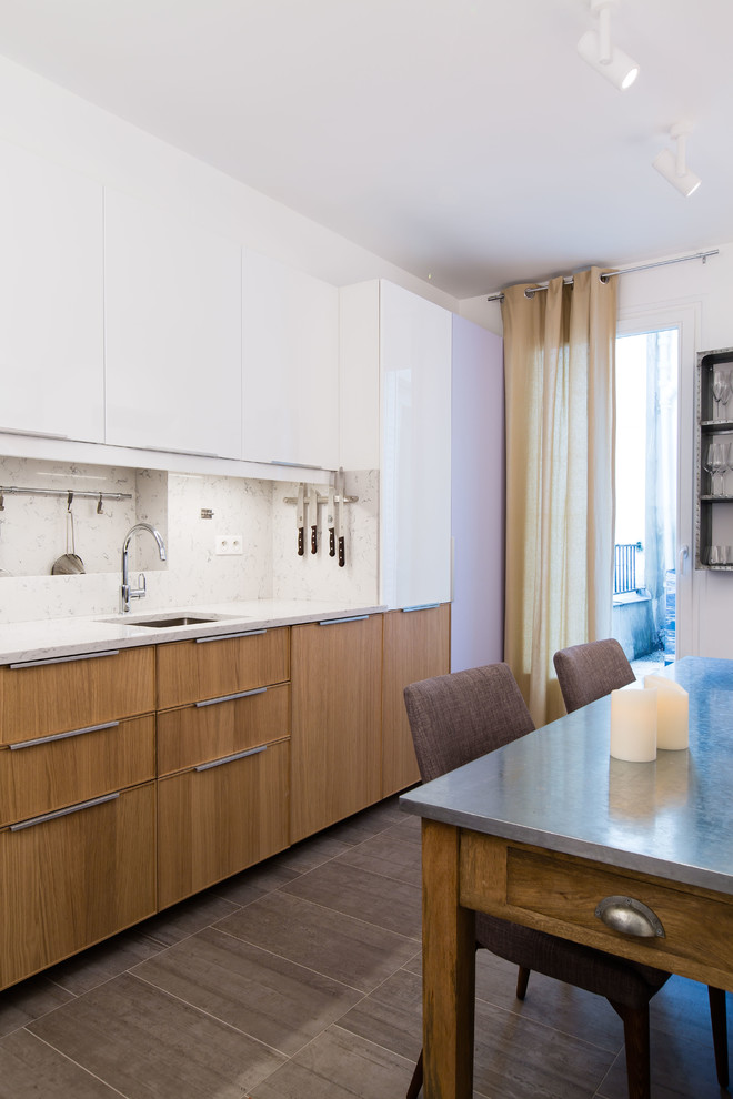 Medium sized contemporary single-wall kitchen/diner in Paris with a submerged sink, medium wood cabinets, marble worktops, white splashback, stone slab splashback, integrated appliances, ceramic flooring and an island.