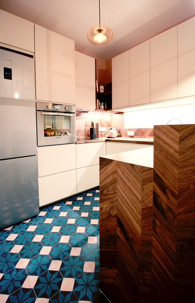 Immagine di una cucina design di medie dimensioni con lavello sottopiano, ante a filo, ante beige, top in legno, paraspruzzi marrone, paraspruzzi in legno, elettrodomestici da incasso, pavimento in cementine e pavimento turchese