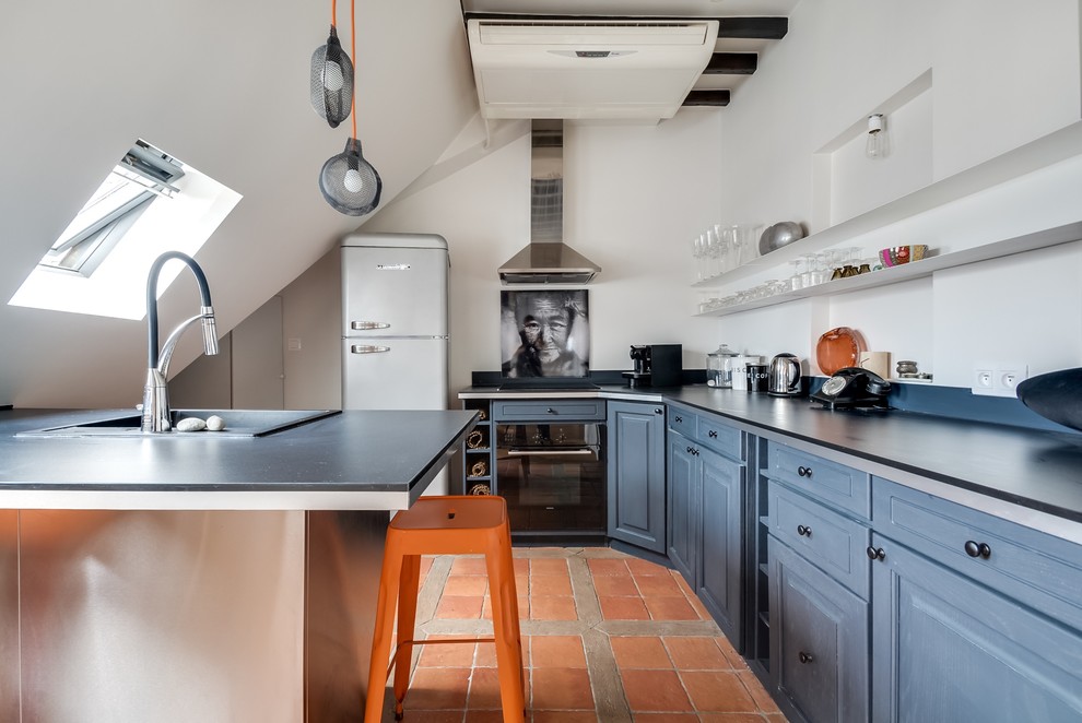 Design ideas for a medium sized traditional u-shaped open plan kitchen in Paris with a built-in sink, raised-panel cabinets, blue cabinets and terracotta flooring.