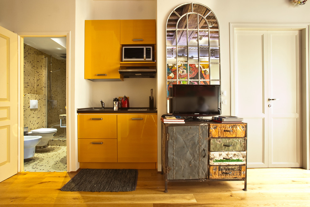 Exemple d'une petite cuisine ouverte linéaire éclectique avec parquet clair, des portes de placard jaunes et aucun îlot.