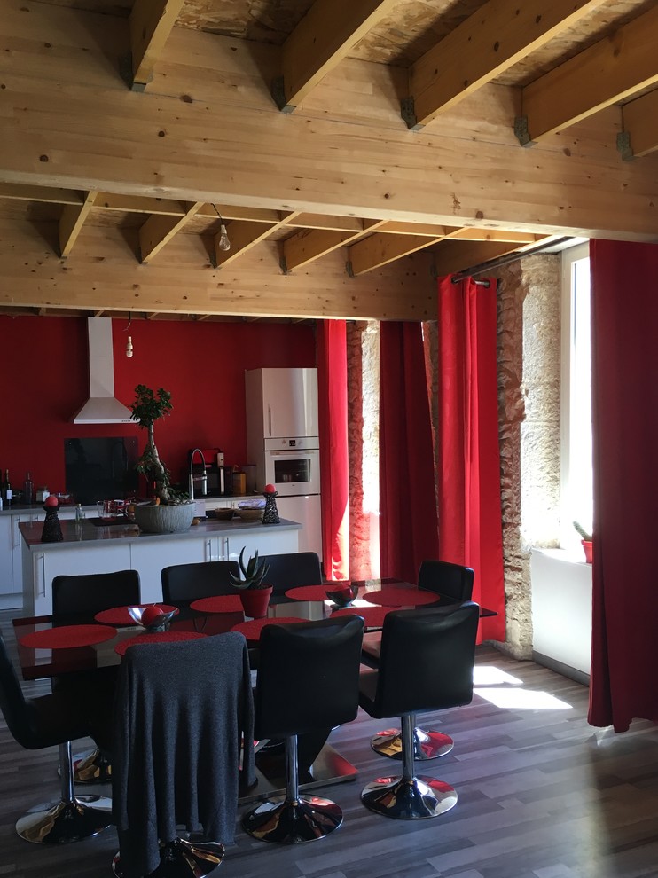 Foto di una cucina mediterranea di medie dimensioni con lavello integrato, ante bianche, top in legno, paraspruzzi rosso, elettrodomestici neri, pavimento in legno massello medio e pavimento marrone