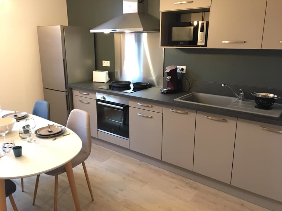 Exemple d'une cuisine linéaire scandinave de taille moyenne avec un évier encastré, un électroménager en acier inoxydable, un sol en vinyl et un sol beige.