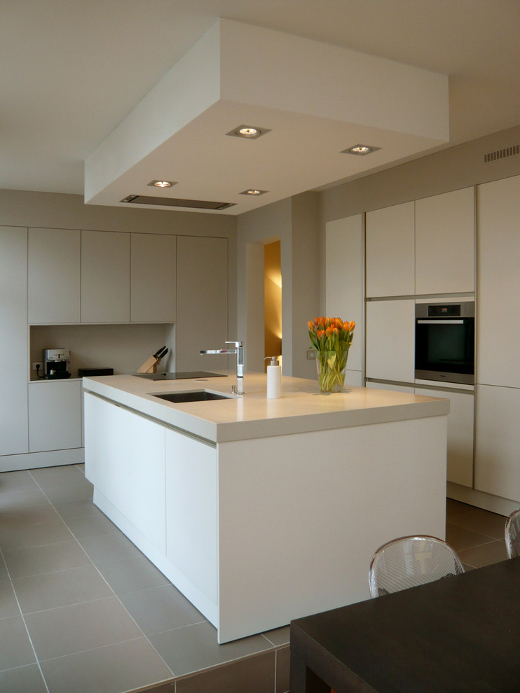 リールにある高級な広いコンテンポラリースタイルのおしゃれなキッチン (アンダーカウンターシンク、フラットパネル扉のキャビネット、白いキャビネット、シルバーの調理設備) の写真