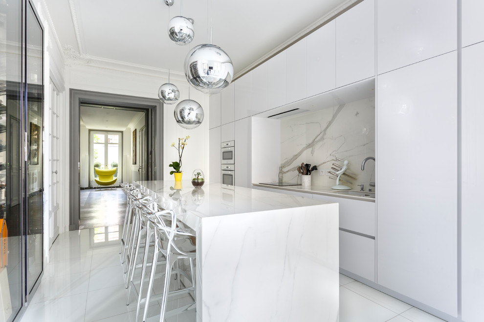 Geschlossene, Zweizeilige Moderne Küche mit flächenbündigen Schrankfronten, weißen Schränken, Küchenrückwand in Weiß, Rückwand aus Stein, Kücheninsel und weißem Boden in Paris