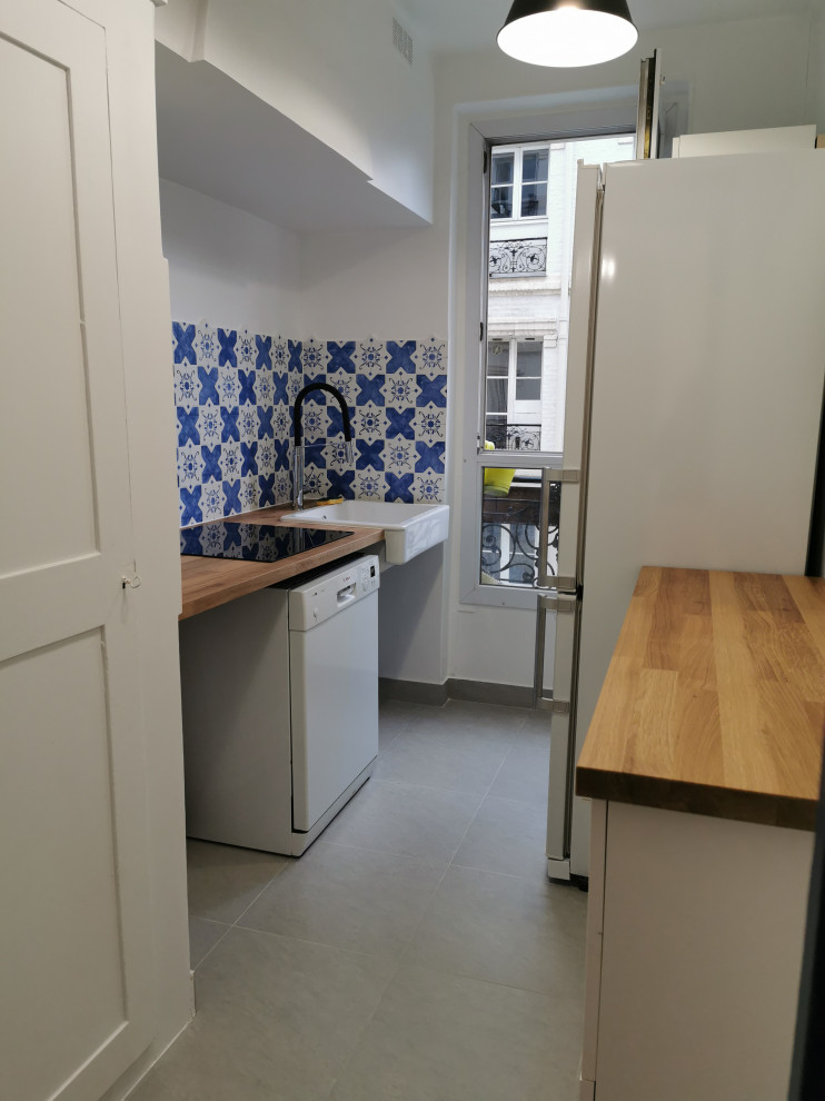 Mediterrane Küche mit Einbauwaschbecken, Arbeitsplatte aus Holz, weißen Elektrogeräten, Keramikboden und grauem Boden in Paris