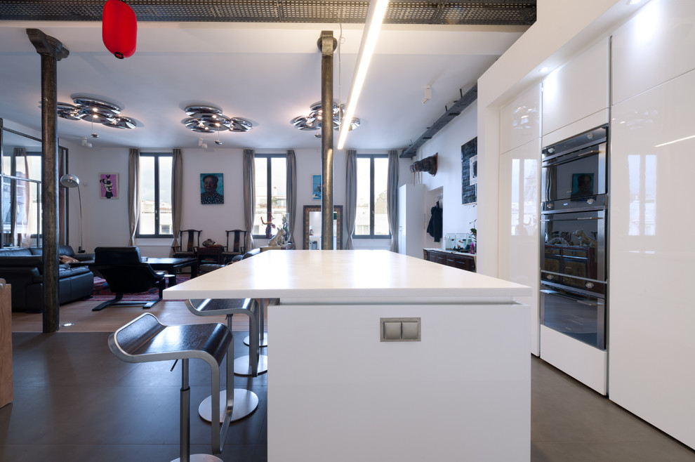 Inspiration for a medium sized modern l-shaped open plan kitchen in Paris with an integrated sink, beaded cabinets, white cabinets, quartz worktops, white splashback, glass tiled splashback, integrated appliances, terracotta flooring and an island.