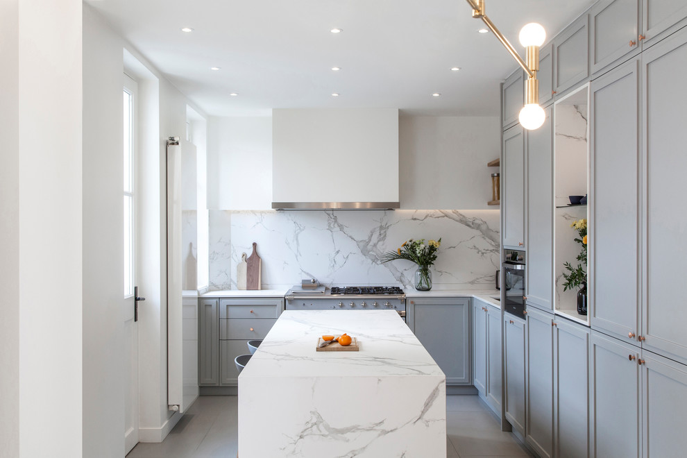 Inspiration for a contemporary l-shaped kitchen in Paris with recessed-panel cabinets, grey cabinets, white splashback, stone slab splashback, an island, grey floors and white worktops.