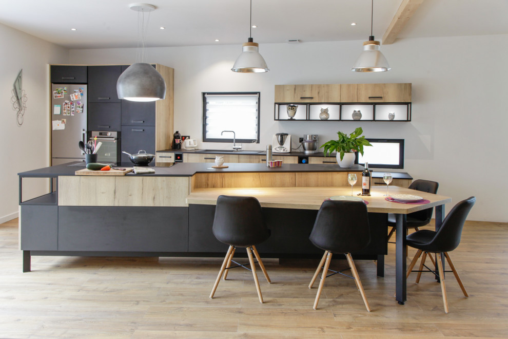 Esempio di una cucina design con lavello sottopiano, ante lisce, ante in legno chiaro, elettrodomestici in acciaio inossidabile, parquet chiaro, pavimento beige e top grigio