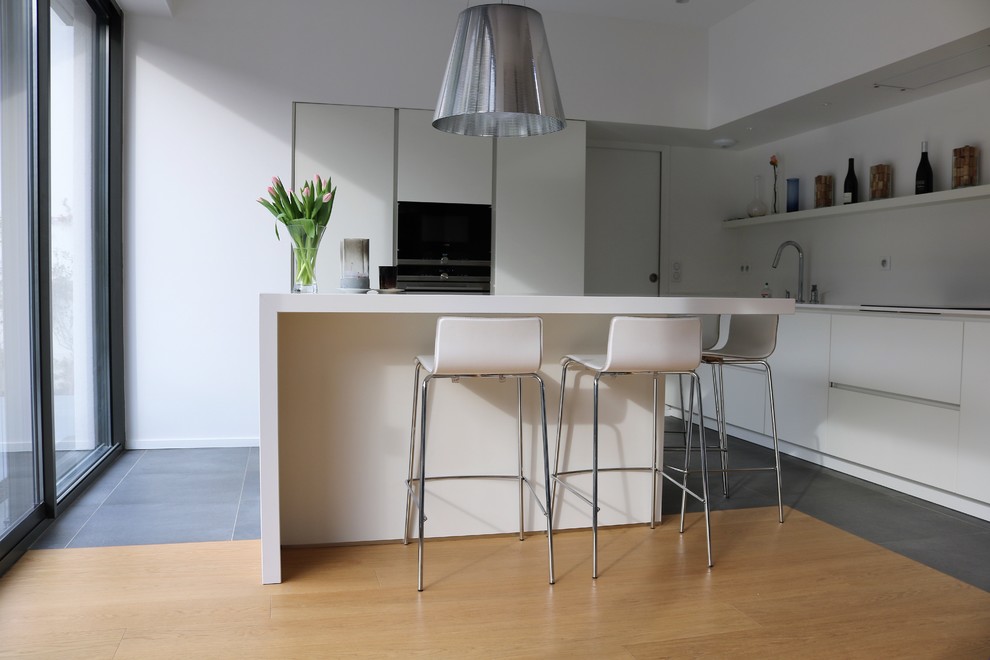 This is an example of a medium sized modern l-shaped open plan kitchen in Paris with an island.