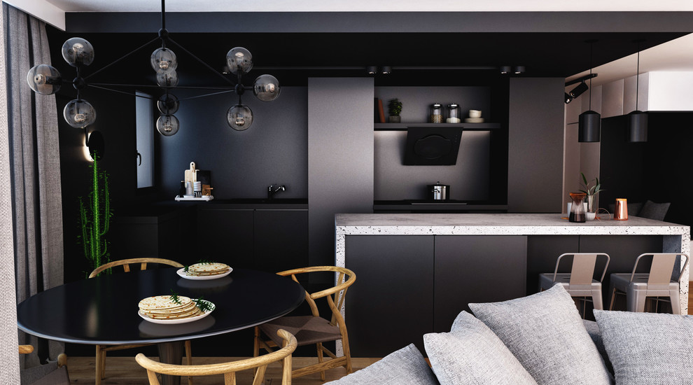 Inspiration pour une cuisine américaine minimaliste en L de taille moyenne avec un placard à porte plane, des portes de placard noires, un plan de travail en béton, une crédence noire, sol en béton ciré, îlot et un sol noir.