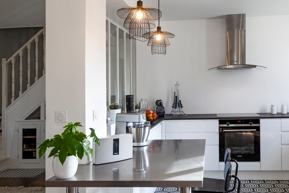 Immagine di una cucina design con lavello integrato, ante bianche, top in quarzo composito, paraspruzzi bianco, pavimento con piastrelle in ceramica, pavimento nero e top marrone