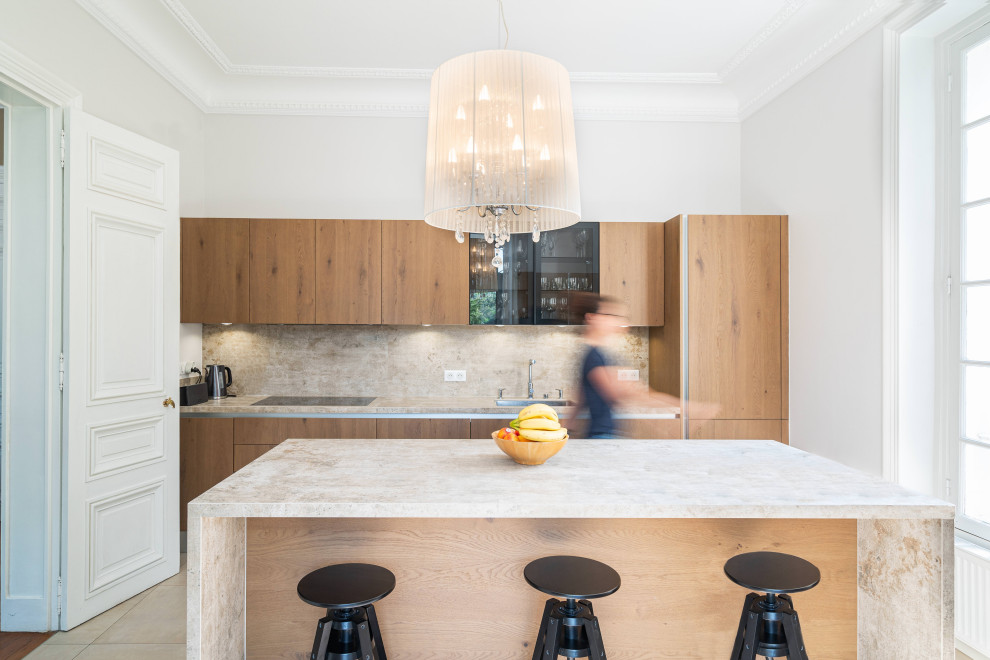 This is an example of a large contemporary single-wall enclosed kitchen in Other with a submerged sink, flat-panel cabinets, light wood cabinets, beige splashback, black appliances, ceramic flooring, an island, beige floors and beige worktops.
