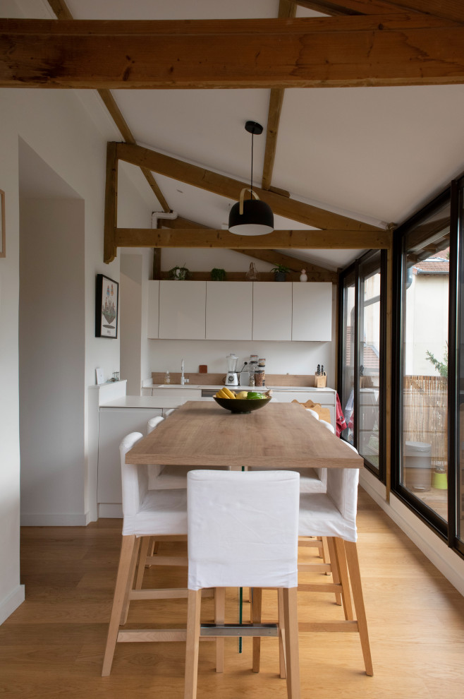 Immagine di una cucina costiera di medie dimensioni con parquet chiaro e travi a vista