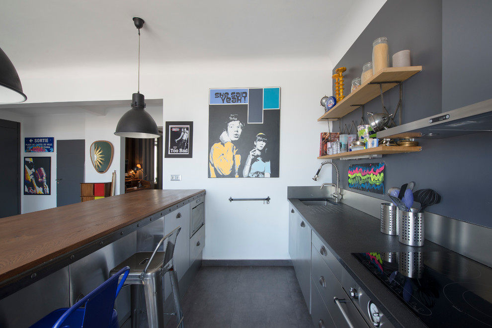 Zweizeilige, Mittelgroße Moderne Wohnküche mit Edelstahlfronten und Halbinsel in Paris