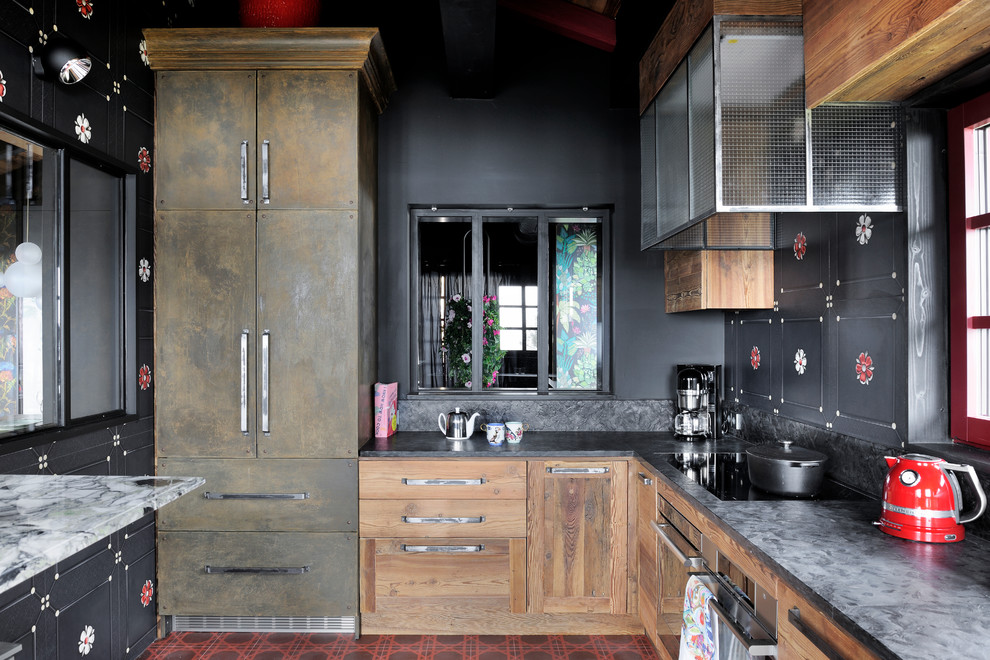 他の地域にあるエクレクティックスタイルのおしゃれなキッチン (フラットパネル扉のキャビネット、中間色木目調キャビネット、黒いキッチンパネル、シルバーの調理設備、アイランドなし、赤い床) の写真