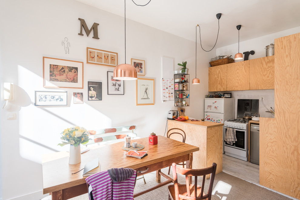 Immagine di una cucina abitabile eclettica con ante lisce, ante in legno chiaro, top in legno, elettrodomestici bianchi, penisola e pavimento beige