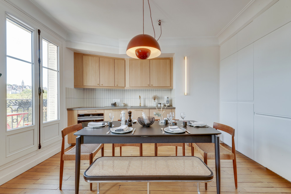 На фото: прямая кухня-гостиная среднего размера в скандинавском стиле с светлыми деревянными фасадами, столешницей из бетона, фартуком из керамической плитки, белым фартуком, светлым паркетным полом, коричневым полом и серой столешницей