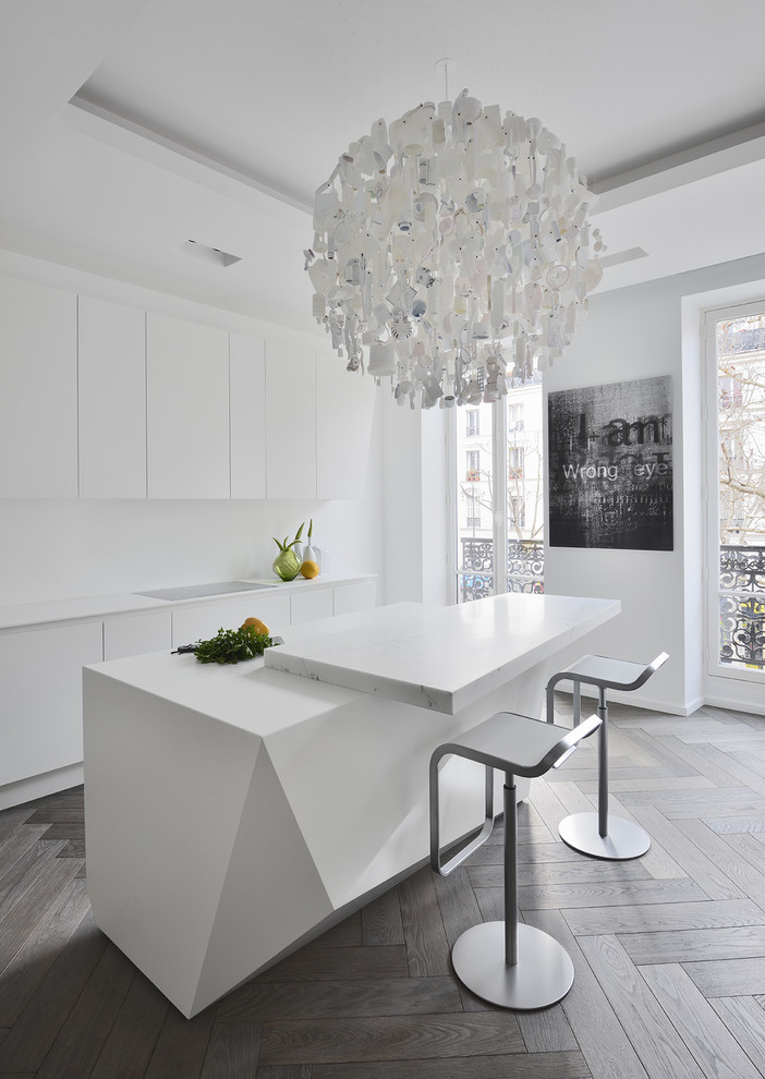 Zweizeilige, Mittelgroße Moderne Wohnküche mit flächenbündigen Schrankfronten, weißen Schränken, Kücheninsel und hellem Holzboden in Paris