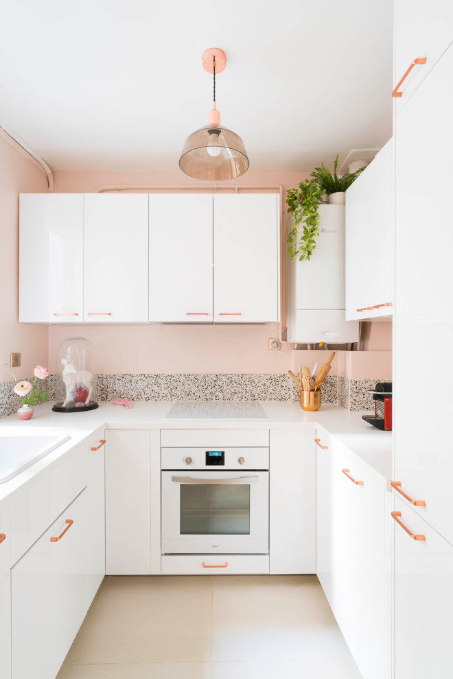 Exempel på ett avskilt, litet modernt vit vitt kök, med en enkel diskho, släta luckor, vita skåp, rosa stänkskydd, integrerade vitvaror och beiget golv