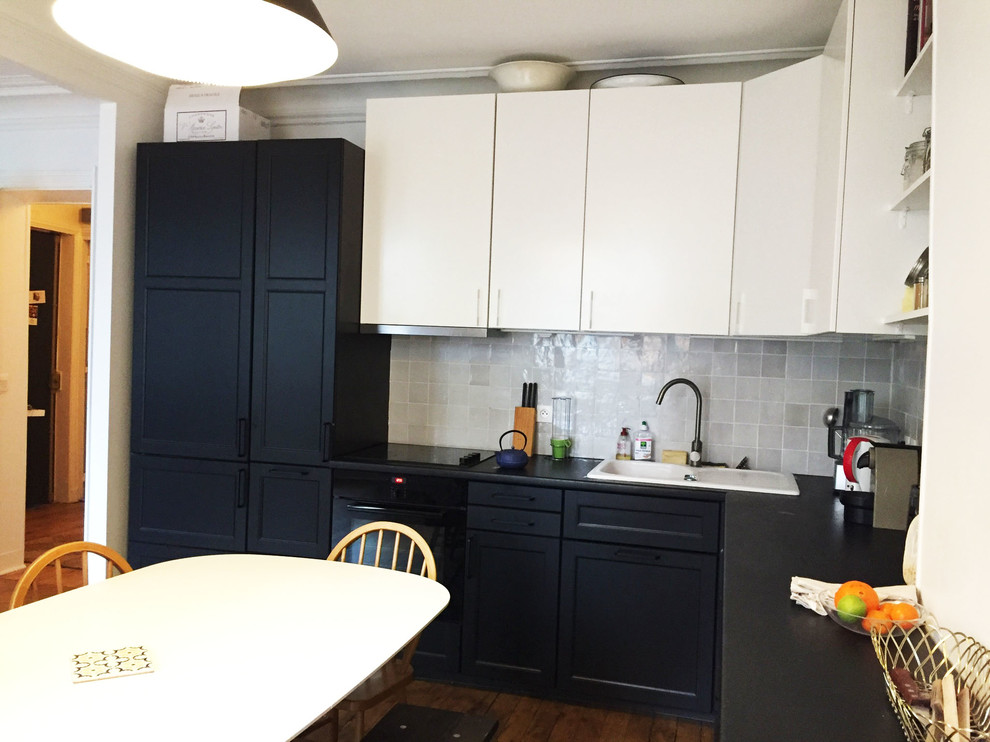 Foto på ett mellanstort eklektiskt kök, med en undermonterad diskho, luckor med infälld panel, svarta skåp, laminatbänkskiva, grått stänkskydd, stänkskydd i terrakottakakel, svarta vitvaror, ljust trägolv och beiget golv