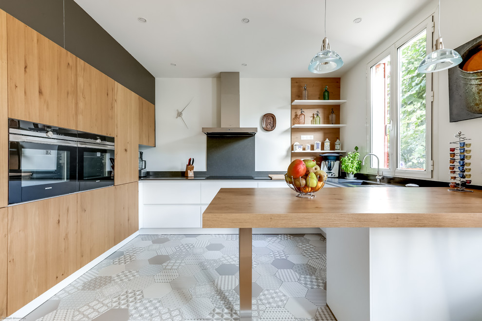 Moderne Wohnküche in U-Form mit Unterbauwaschbecken, flächenbündigen Schrankfronten, hellbraunen Holzschränken, Arbeitsplatte aus Holz, Halbinsel und Küchenrückwand in Weiß in Paris