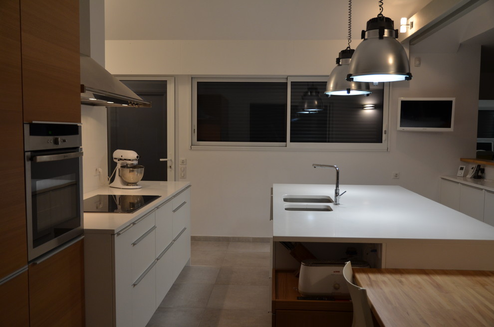 Cette image montre une grande cuisine ouverte parallèle design avec un plan de travail en granite et îlot.