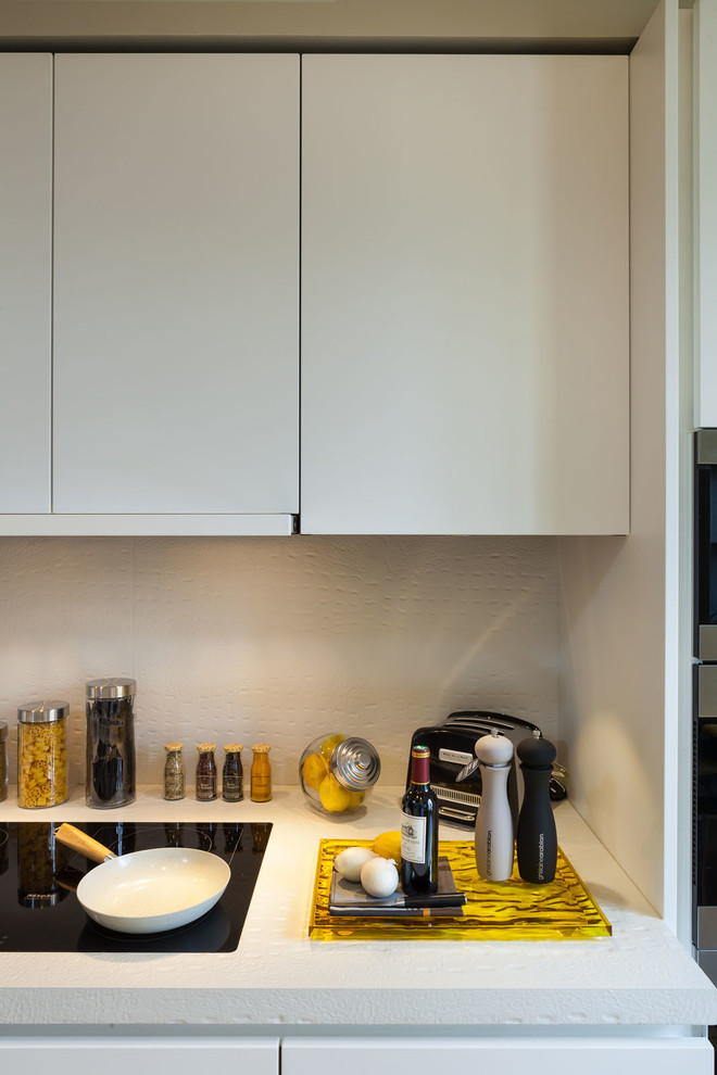 Photo of an expansive contemporary galley enclosed kitchen in Paris with a single-bowl sink, concrete worktops, white splashback and cement tile splashback.