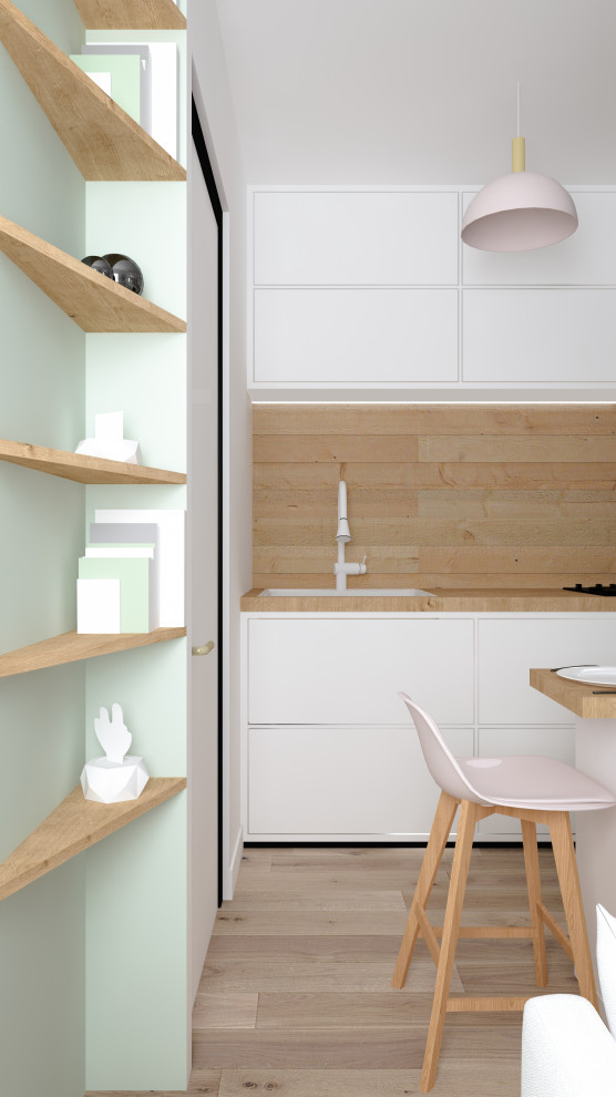 Idéer för små industriella linjära beige kök med öppen planlösning, med en undermonterad diskho, vita skåp, träbänkskiva, beige stänkskydd, stänkskydd i trä, mellanmörkt trägolv och brunt golv
