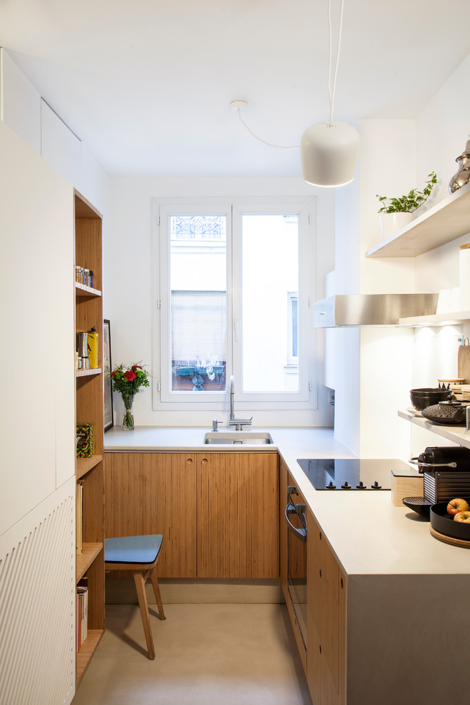 パリにある小さなコンテンポラリースタイルのおしゃれなキッチン (フラットパネル扉のキャビネット、中間色木目調キャビネット、黒い調理設備、アイランドなし、アンダーカウンターシンク、白いキッチンパネル、窓) の写真
