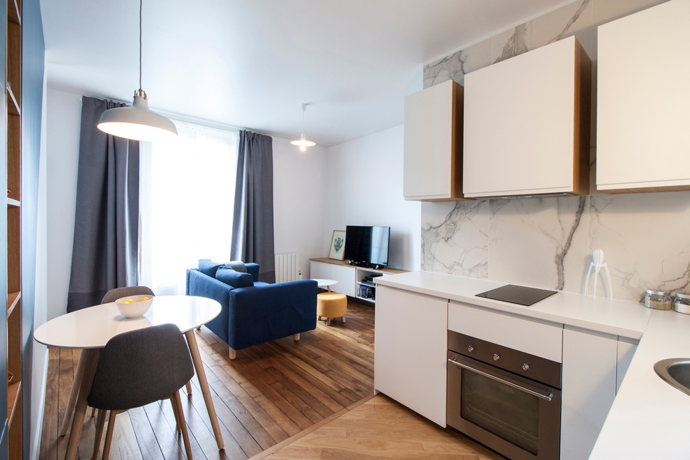Photo of a small contemporary l-shaped open plan kitchen in Paris with a submerged sink, flat-panel cabinets, white cabinets, stainless steel worktops, white splashback, white appliances, light hardwood flooring and no island.