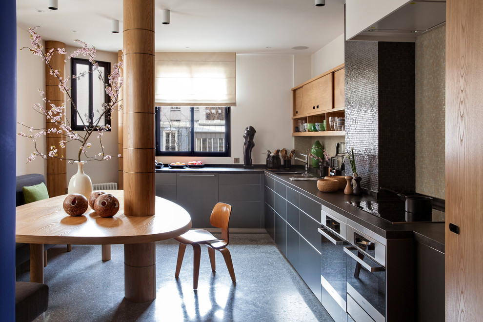 Inspiration för mellanstora moderna kök, med en undermonterad diskho, släta luckor, grå skåp, svart stänkskydd, stänkskydd i mosaik och rostfria vitvaror