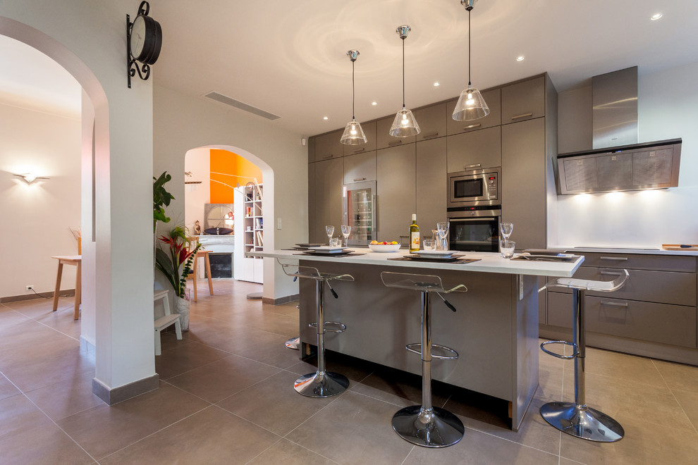 Große, Zweizeilige Moderne Wohnküche mit flächenbündigen Schrankfronten, grauen Schränken, Küchengeräten aus Edelstahl und Kücheninsel in Nizza