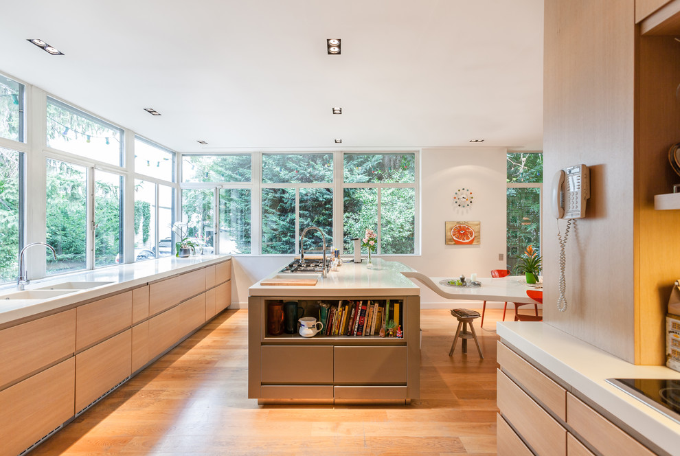 Идея дизайна: отдельная, параллельная кухня среднего размера в современном стиле с плоскими фасадами, островом, двойной мойкой, светлыми деревянными фасадами, светлым паркетным полом и окном