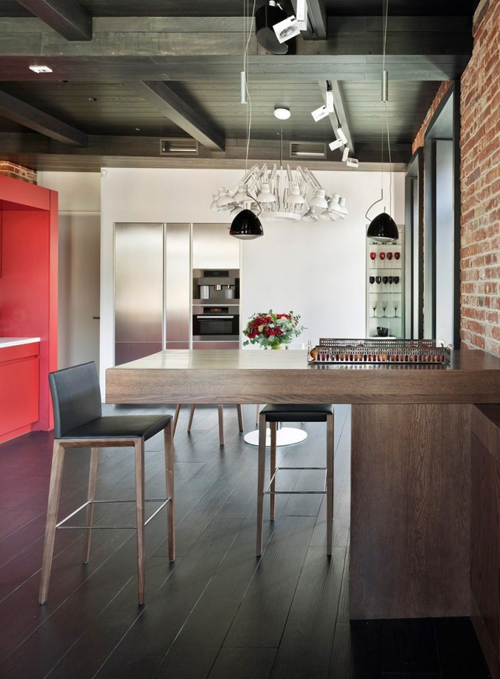 Einzeilige, Mittelgroße Moderne Wohnküche mit flächenbündigen Schrankfronten, roten Schränken, Küchengeräten aus Edelstahl, dunklem Holzboden und Halbinsel in Lyon