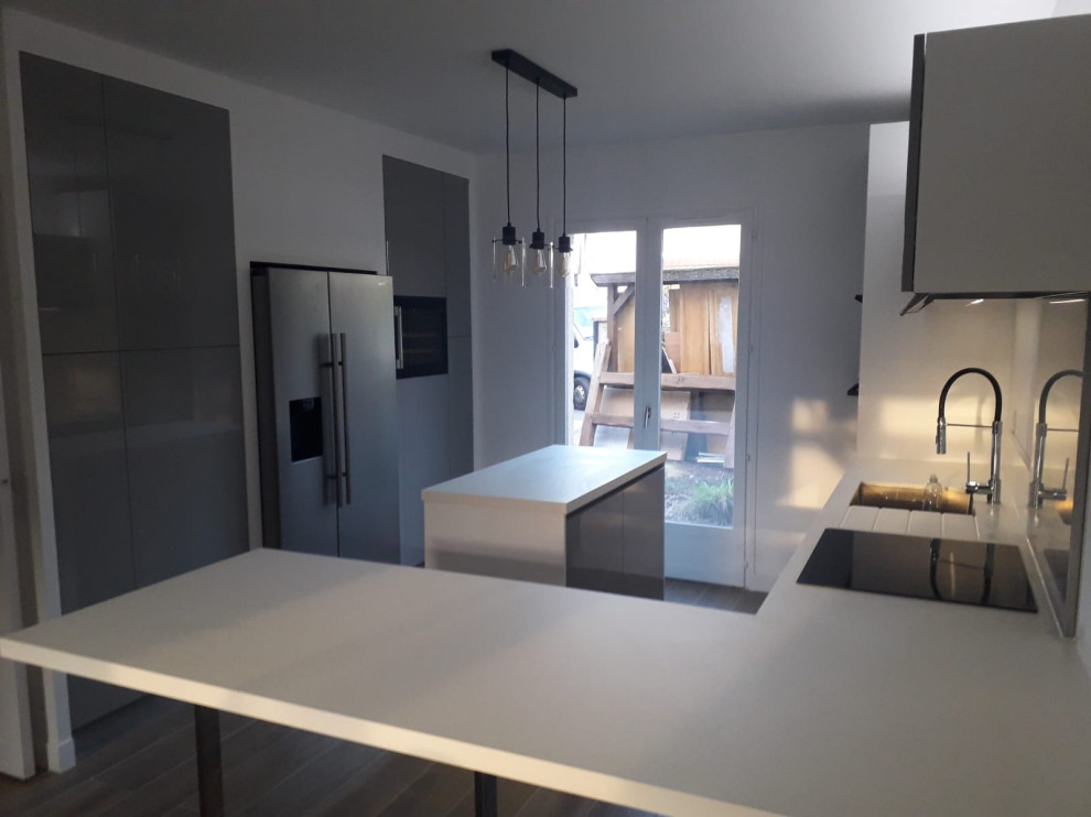 Foto på ett stort funkis vit kök, med en integrerad diskho, luckor med infälld panel, grå skåp, träbänkskiva, grått stänkskydd, stänkskydd i metallkakel, integrerade vitvaror, laminatgolv, en köksö och grått golv