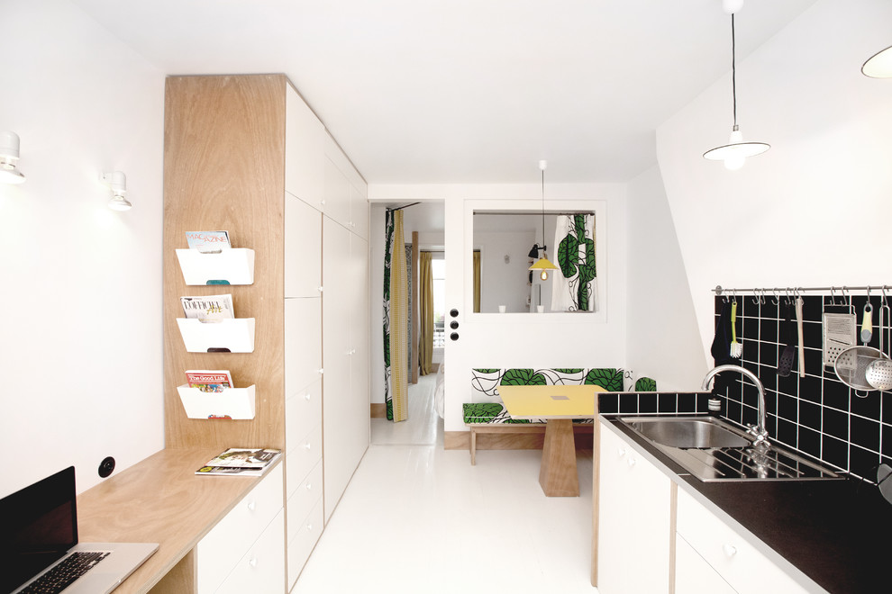 Kleine, Zweizeilige Moderne Wohnküche mit flächenbündigen Schrankfronten, Küchenrückwand in Schwarz und Rückwand aus Keramikfliesen in Paris