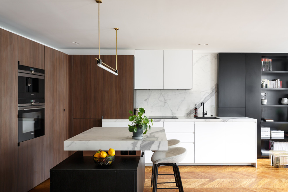 Idéer för mellanstora funkis vitt kök, med en undermonterad diskho, luckor med profilerade fronter, skåp i mellenmörkt trä, marmorbänkskiva, vitt stänkskydd, stänkskydd i marmor, svarta vitvaror, mellanmörkt trägolv, en köksö och brunt golv