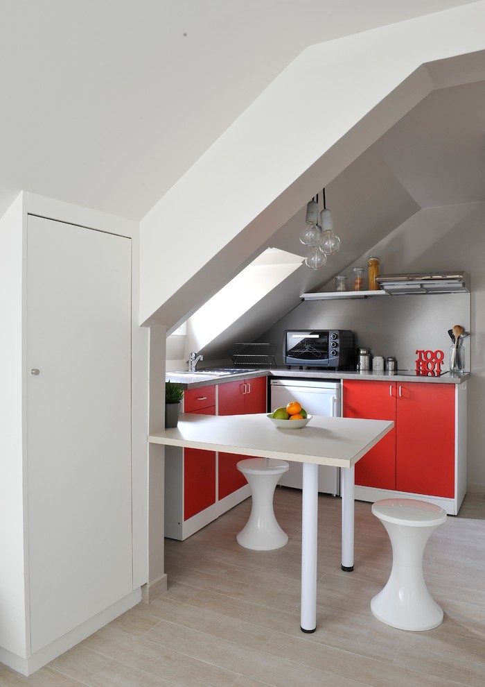 Ejemplo de cocina rectangular actual pequeña con armarios con paneles lisos, puertas de armario rojas, suelo de madera clara y península
