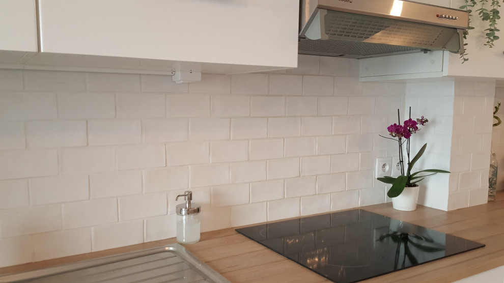 Idéer för att renovera ett mellanstort funkis linjärt kök med öppen planlösning, med en enkel diskho, släta luckor, vita skåp, laminatbänkskiva, vitt stänkskydd, stänkskydd i keramik, rostfria vitvaror, klinkergolv i keramik och grått golv