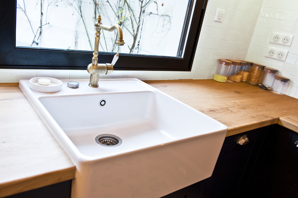 Photo of a large retro u-shaped open plan kitchen in Paris with a belfast sink, recessed-panel cabinets, blue cabinets, wood worktops, white splashback, metro tiled splashback, stainless steel appliances, cement flooring, an island, multi-coloured floors and multicoloured worktops.