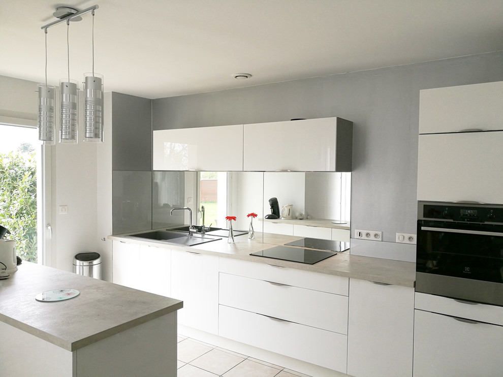 Immagine di una cucina minimalista di medie dimensioni con paraspruzzi a specchio