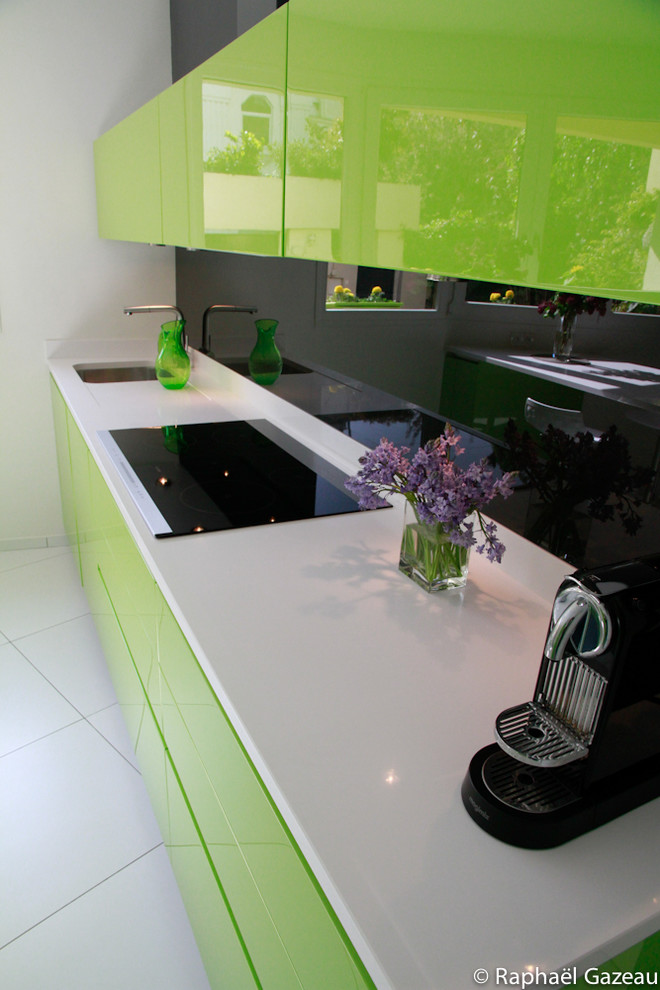 Exempel på ett modernt kök, med gröna skåp, bänkskiva i kvartsit och svart stänkskydd