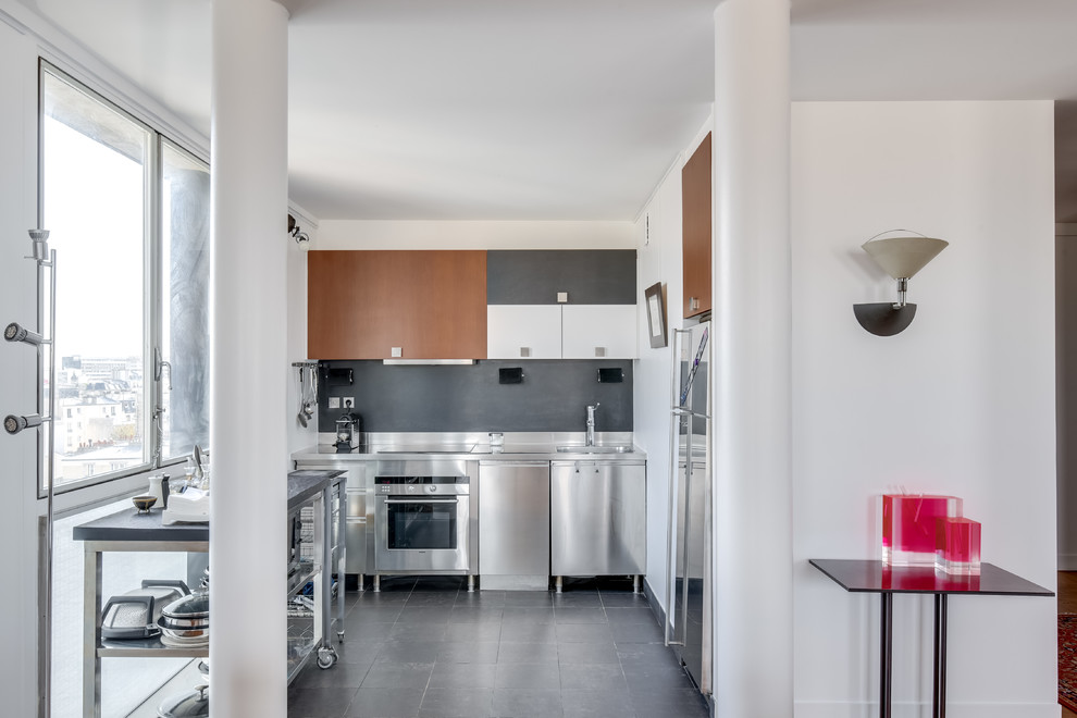Foto på ett mellanstort eklektiskt kök, med en enkel diskho, svart golv, luckor med profilerade fronter, bruna skåp, bänkskiva i rostfritt stål, grått stänkskydd, stänkskydd i skiffer, rostfria vitvaror och klinkergolv i keramik
