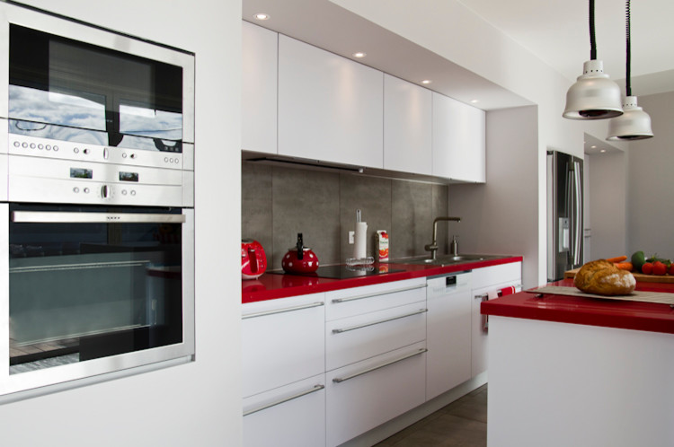 ボルドーにあるお手頃価格の中くらいなコンテンポラリースタイルのおしゃれなキッチン (アンダーカウンターシンク、インセット扉のキャビネット、白いキャビネット、ラミネートカウンター、グレーのキッチンパネル、シルバーの調理設備、赤いキッチンカウンター) の写真